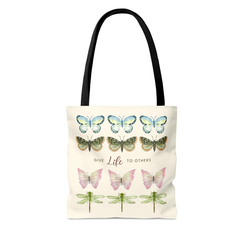 Vintage butterfly and dragonfly AOP Tote Bag! The tote bag has 3 times 3 Butterflies in a row in colours yellow-blue, green, yellow-pink, and 1 time dragonflies in light green. In the middle is a saying: Give live to others.