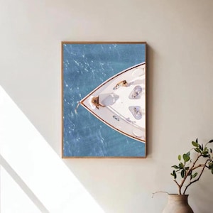 May include: A framed photograph of a white boat on the water. The boat is viewed from above, and the water is a light blue color.