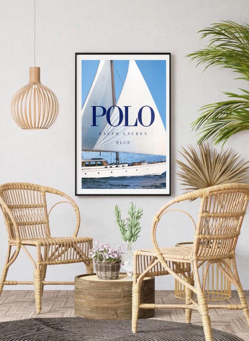 Peut inclure: Une affiche encadr&eacute;e avec un voilier bleu et blanc sur une mer bleue avec le texte "POLO RALPH LAUREN BLUE" en bleu marine.