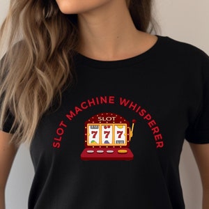 May include: Black t-shirt with a red and white slot machine graphic and the text "Slot Machine Whisperer".