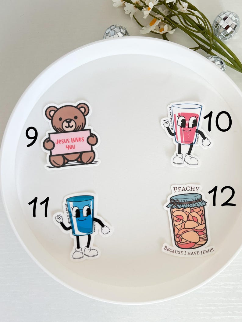 May include: Four stickers on a white background. The stickers are numbered 9, 10, 11, and 12. The stickers feature a brown teddy bear holding a sign that says "Jesus Loves You", a pink cartoon glass of juice, a blue cartoon glass of water, and a jar of peaches with the text "Peachy Because I Have Jesus".