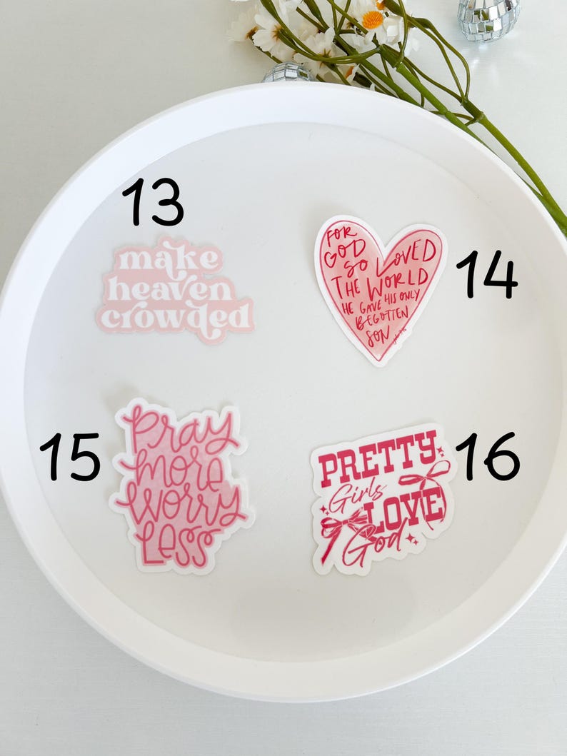May include: Four pink and red stickers with religious and inspirational messages. The stickers are numbered 13, 14, 15, and 16. The stickers say "make heaven crowded", "for God so loved the world he gave his only begotten son", "pray more worry less", and "pretty girls love God".