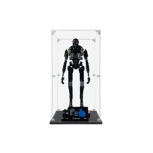 May include: A black and gray robot figure, displayed inside a clear acrylic case. The robot has a detailed design with articulated limbs and a rounded head. The base of the case is black, with small details and text. The overall height of the robot is approximately 12 inches.