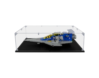 May include: A blue, yellow, and gray toy spaceship model inside a clear display case with a black base. The spaceship has the text "LL 928" printed on the side. The display case is rectangular and transparent.