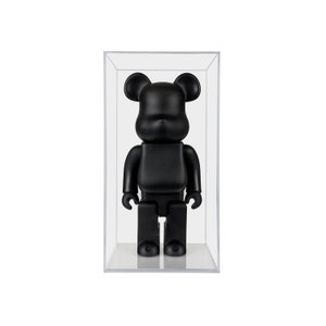 May include: A black bear-shaped toy figure in a clear plastic display case.