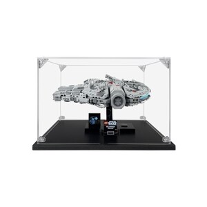 May include: A clear acrylic display case with a black base, showcasing a detailed LEGO Star Wars Millennium Falcon model. The model is in a gray and white color scheme with red accents. The case has a black base with the LEGO Star Wars logo and the words "Millennium Falcon" printed on it.