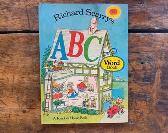 May include: A vintage children's book titled "Richard Scarry's ABC Word Book" featuring a colorful illustration of a house with the letters A, B, and C on the front. The book is published by Random House.