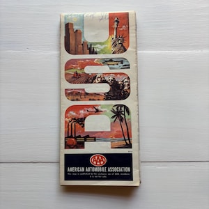 May include: Vintage AAA (American Automobile Association) road map featuring a colorful illustration of the word "USA" with iconic landmarks like the Statue of Liberty, Mount Rushmore, and the Golden Gate Bridge. The map is published for the exclusive use of AAA members and is not for sale.