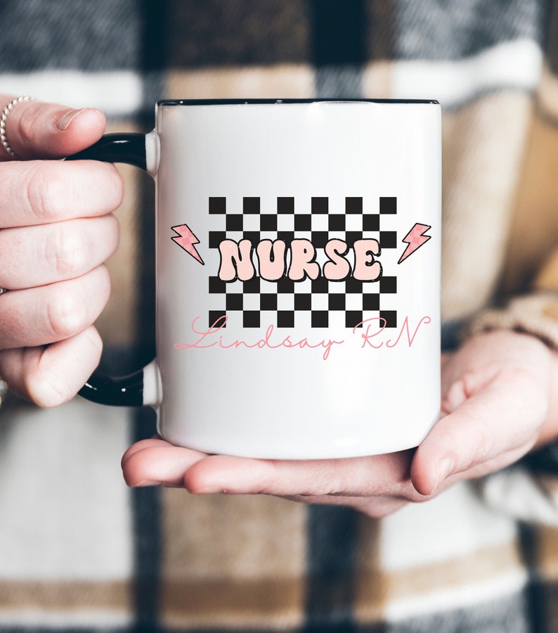 May include: White ceramic mug with a black checkered design and the word "NURSE" in pink letters. The name "Lindsay RN" is written in cursive below the checkered design.