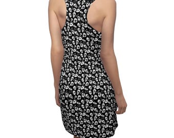 May include: Black and white skull print dress. The sleeveless dress features a racerback design and a knee-length hemline. The all-over pattern includes white skulls and crossbones on a black background. The dress is made of a soft, stretchy fabric.