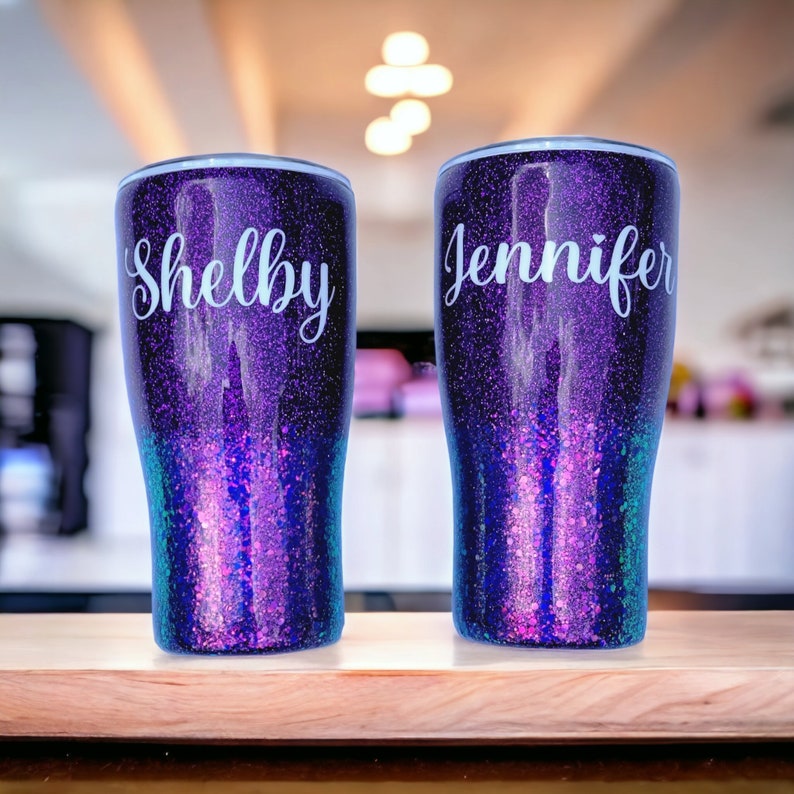 May include: Two purple glitter tumblers with names "Shelby" and "Jennifer" in white lettering.