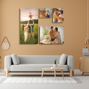 May include: A living room with a light grey sofa, a wooden coffee table, and a light brown wall with four framed photos of a family. The photos show a couple holding a baby, a couple standing in a field, a couple standing in a kitchen, and a child standing in a room.