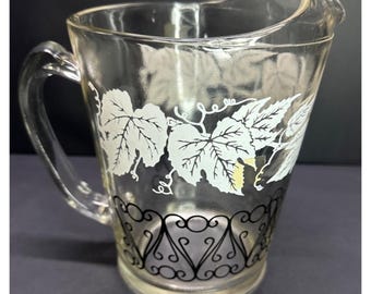 Vintage glazen kan in Bartlett Collins-stijl met geëtst druivenrankmotief, 20 cm hoog.
