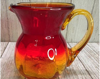 Vintage Amberina stijl handgeblazen kunstglazen melkkannetje met rood en geel handvat, 10 cm hoog, tweekleurig.