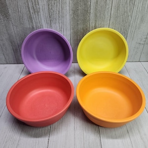 Puede incluir: Cuatro cuencos coloridos hechos de fibra de bambú. Los cuencos son morado, amarillo, naranja y rojo.