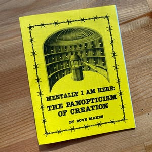 May include: A yellow booklet with a black and white illustration of a panopticon prison. The text on the cover reads "Mentally I Am Here: The Panopticism of Creation by Dove Makes."