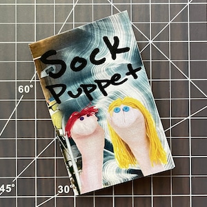 Puede incluir: Dos marionetas de calcetines, una roja y otra rubia, con el texto "Sock Puppet" escrito en negro sobre un fondo azul y blanco.