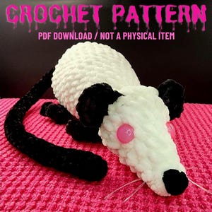 May include: A handmade crochet opossum plushie with a white body, black ears, tail, and feet, and pink eyes. The text "CROCHET PATTERN" and "PDF DOWNLOAD / NOT A PHYSICAL ITEM" are displayed at the top of the image.