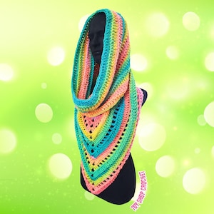 May include: A rainbow-colored crochet cowl scarf. The scarf features a gradient of colors, including pink, yellow, green, and blue. The scarf is displayed on a black mannequin head and torso. The text "TOY SHOP CROCHET" is visible on the bottom right.