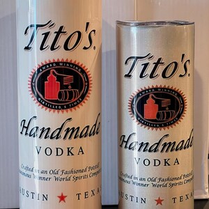 Pu&ograve; includere: Due bicchieri in acciaio inossidabile con fondo bianco e glitter dorati. I bicchieri presentano il logo della vodka Tito's, le parole "Vodka artigianale" e il testo "Prodotta in un alambicco tradizionale,  Vincitrice del concorso mondiale di liquori, Austin, Texas".