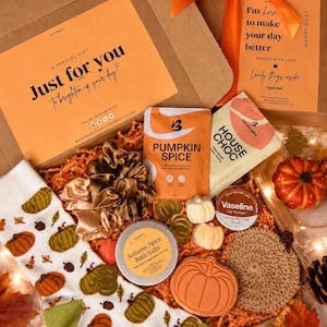 May include: A gift box containing white socks with a pumpkin pattern, two satin scrunchies, a packet of pumpkin spice, a packet of house chocolate, a tin of autumn spice bath salts, a pumpkin-shaped soap, and a Vaseline lip therapy tin.