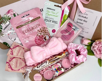 Könnte beinhalten: Eine rosa Geschenkbox gefüllt mit Selbstpflegeartikeln, darunter Gesichtsmasken, Fußpeeling, ein Stirnband, Badesalz, Kerzen und Süßigkeiten. Die Box ist mit einem rosa Band und dem Text "Happy Post" und "Here to make your day better" verziert.