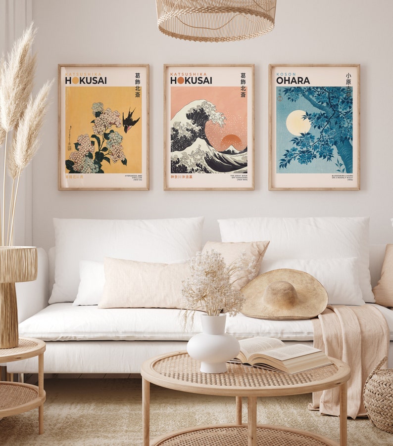 May include: Three framed prints of Japanese woodblock prints. The prints are in a minimalist style with a white background and black text. The prints feature a wave, a flower, and a tree. The text on the prints reads "KATSUSHIKA HOKUSAI" and "葛飾北斎".
