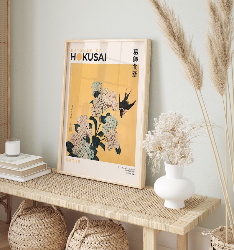 May include: A framed print of a Japanese woodblock print by Katsushika Hokusai, depicting hydrangeas and a swallow. The print is titled "Hydrangeas and Swallow (1832-34)" and is in a light wood frame.