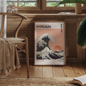 May include: A framed print of "The Great Wave off Kanagawa" by Katsushika Hokusai. The print features a large wave with Mount Fuji in the background. The text "KATSUSHIKA HOKUSAI" and "神奈川沖浪裏" is printed in the bottom left corner.