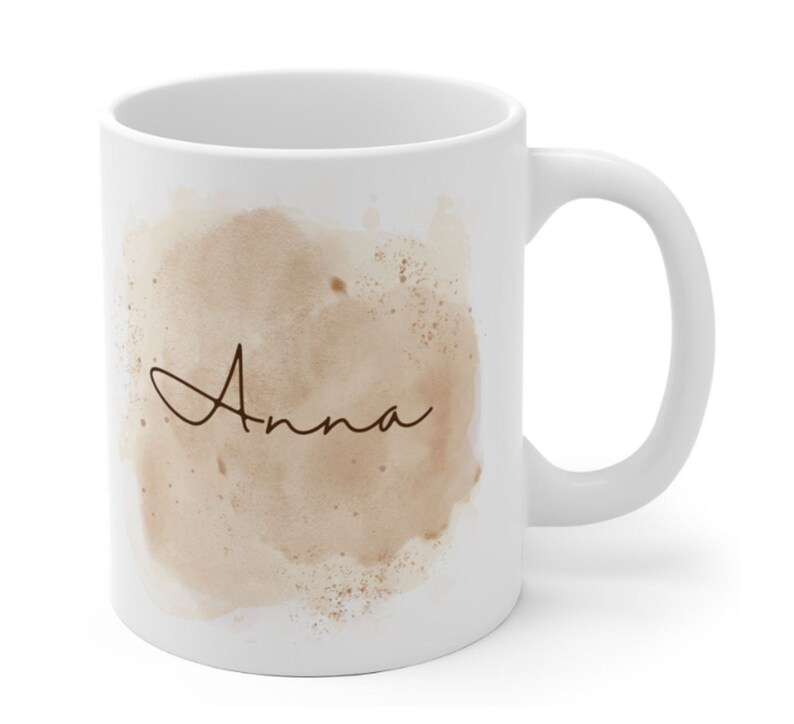 May include: White ceramic mug with a brown watercolor design and the name "Anna" in cursive script.