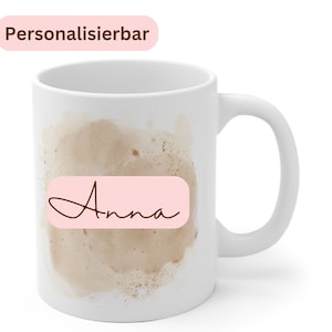 May include: White ceramic mug with a brown watercolor design and a pink rectangle with the name "Anna" written in brown cursive.
