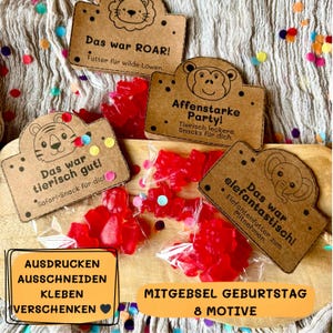 May include: A collection of red gummy candies in clear plastic bags, arranged with decorative brown tags featuring animal illustrations and German text. The tags read "Das war ROAR!", "Affenstarke Party!", "Das war tierisch gut!", and "Das war elefantastisch!".