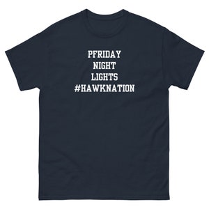 May include: Navy blue t-shirt with white text that reads "PFRIDAY NIGHT LIGHTS #HAWKNATION".