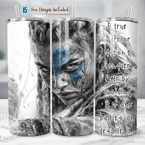 May include: A stainless steel tumbler with a black and white image of a warrior woman with blue face paint. The tumbler has a quote that reads "A true warrior doesn't conquer fear by avoiding it - she battles on despite it."