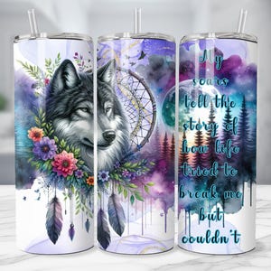Puede incluir: Un juego de tres vasos de acero inoxidable con un dise&ntilde;o de acuarela. Los vasos presentan un lobo, un atrapasue&ntilde;os y una escena de bosque. El texto en el vaso dice "Mis cicatrices cuentan la historia de c&oacute;mo la vida intent&oacute; romperme pero no pudo."