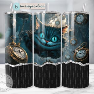 May include: A set of three stainless steel tumblers with a whimsical design featuring the Cheshire Cat from Alice in Wonderland. The design includes pocket watches and the text "15 Free Designs Included". The bottom of the tumblers have a black and silver pattern.