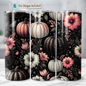 May include: Three stainless steel tumblers with a floral and pumpkin design. The design features pink flowers, white flowers, and pumpkins on a black background. The text "15 free designs included" is at the top.