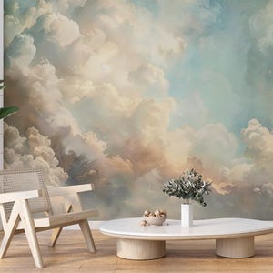 May include: A room interior featuring a large mural of a cloudy sky in shades of beige, blue, and peach. A light wood chair, a white coffee table, and a potted plant are in front of the mural. A vase with greenery sits on the table.