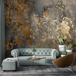 Può includere: Un design di interni per un soggiorno con un divano imbottito blu turchese, due tavolini rotondi in metallo dorato, un pouf grigio chiaro, una poltrona in pelle marrone e una parete con una carta da parati testurizzata oro e grigia.