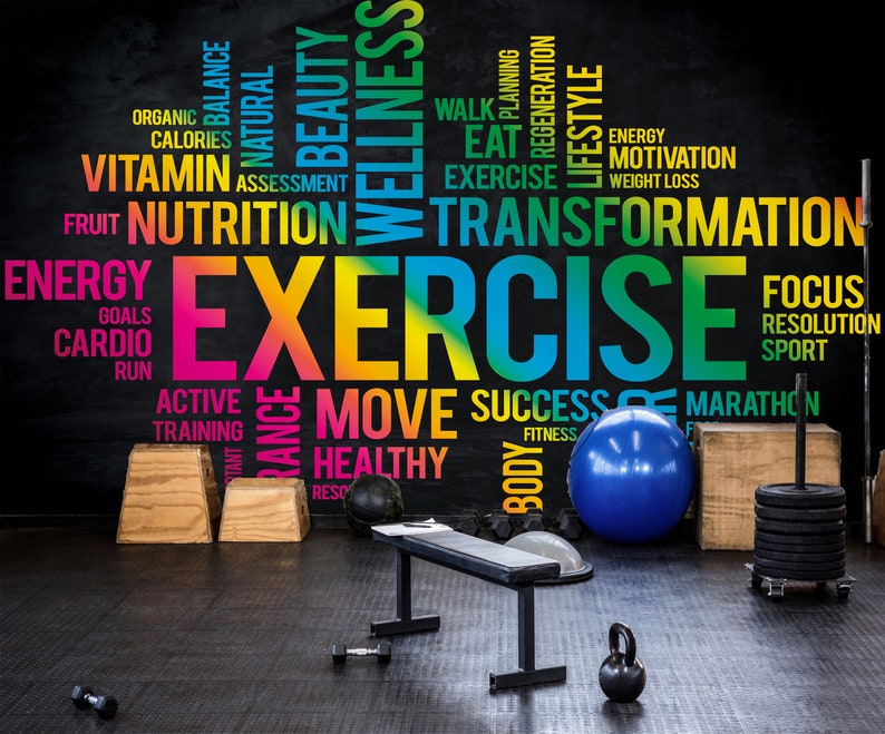 May include: A gym with a black wall featuring a colorful word cloud with the word "EXERCISE" in the center. The word cloud includes words related to fitness, health, and wellness. The gym has a bench, weights, a medicine ball, and other exercise equipment.