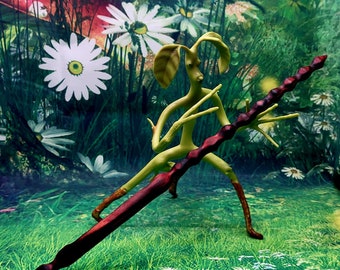 Könnte beinhalten: Eine grüne, zweigartige Figur mit langen Armen und Beinen hält einen dunkelroten und braunen Holzstab. Die Figur steht auf einer Wiese mit grünem Gras und weißen Blumen. Ein blauer Schmetterling fliegt im Hintergrund.