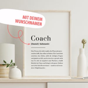 Könnte beinhalten: Ein gerahmter Druck mit dem Wort "Coach" und seiner Definition. Der Druck enthält den Text "MIT DEINEM WUNSCHNAMEN" in einer Sprechblase. Der Druck wird auf einem weißen Regal mit dekorativen Gegenständen präsentiert.