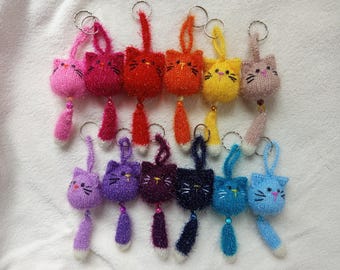 Puede incluir: Un conjunto de 10 llaveros de gato de punto de colores vivos con colas esponjosas. Cada llavero presenta un color diferente y una linda carita de gato.