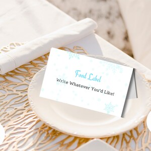 Un pequeño copo de nieve está en camino Etiqueta de comida para baby shower / Tarjetas de lugar para revelar el género del bebé en invierno imprimibles / Plantilla Canva / Plegado en carpa navideña