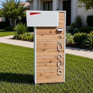 May include: A freestanding mailbox featuring a white metal box with a red flag, mounted on a vertical wooden plank post. The post displays the white house numbers 20605 arranged vertically and includes a small solar light fixture at the top.