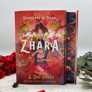 May include: A red, orange, and gold fantasy novel cover with the title "Zhara" and the words "Guardians of Dawn" and "S. Jae-Jones, New York Times Bestselling Author". The cover features a woman with long dark hair holding a pink flower in her hands.