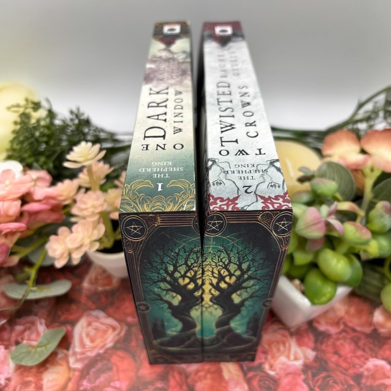 May include: Two fantasy novels, The Shepherd King: One Dark Window and The Shepherd King: Two Twisted Crowns. The books are spine-to-spine, with a dark green and gold design featuring two trees.