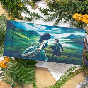 May include: A rectangular set of book spines featuring a continuous illustration of a person in a long dress reaching toward a person in a kilt, set against a vibrant green landscape of rolling hills under a bright blue sky with white clouds.