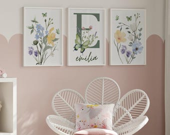 May include: Three framed prints with watercolor floral designs and butterflies. The middle print features the letter "E" and the name "emilia" in cursive.