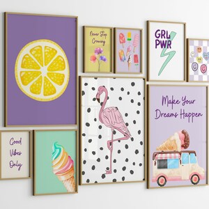 May include: A gallery wall of framed prints with various designs, including a lemon slice, a flamingo, ice cream cones, and inspirational quotes like "Good Vibes Only" and "Make Your Dreams Happen".